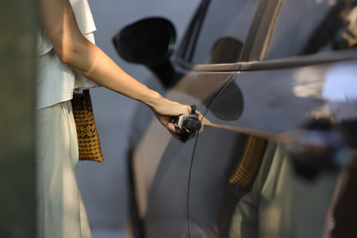 A woman opens the door to her car in a Utah multifamily unit parking lot