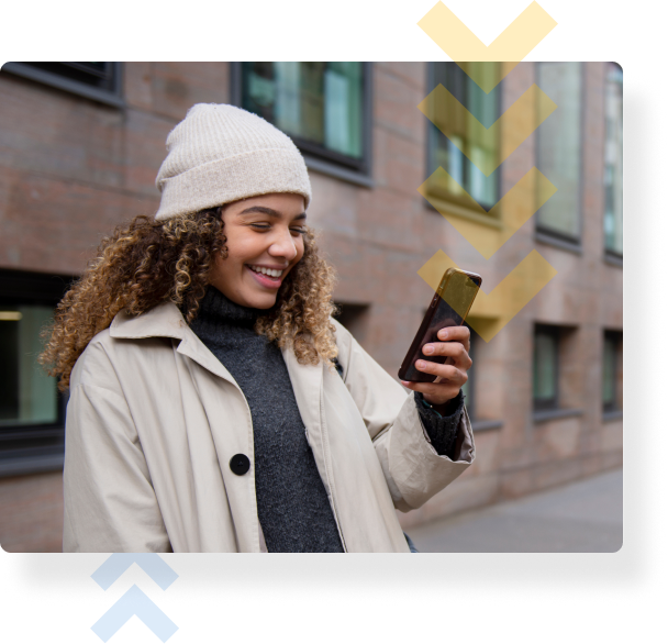 A young woman smiling and purchasing a permit on her phone outside