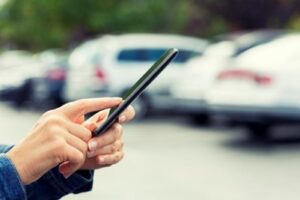 A resident uses their phone to access their parking payment technology 