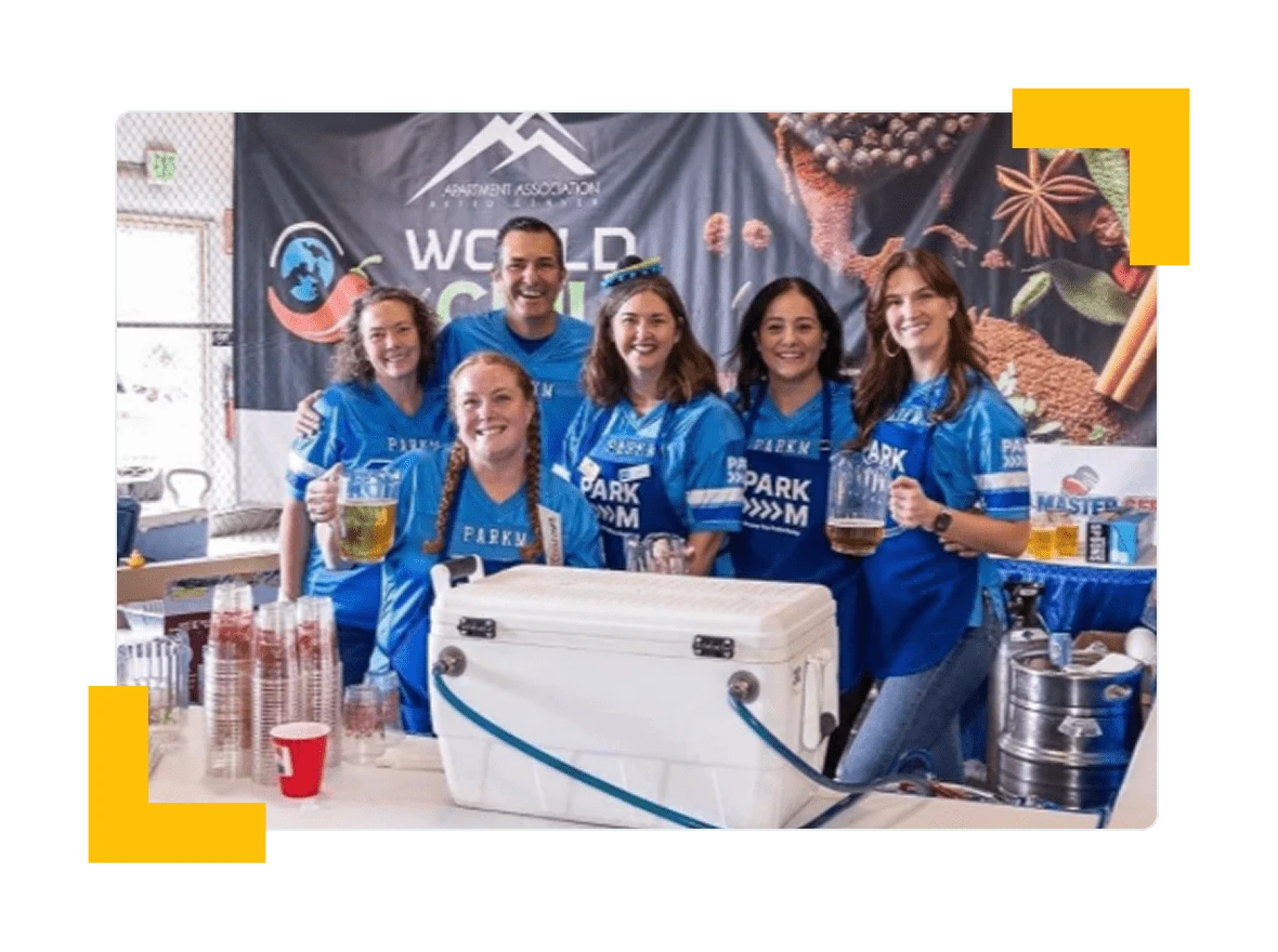 ParkM team in ParkM jerseys and aprons serving drinks at an apartment association chili cook-off