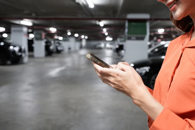Resident checking her phone in an apartment parking garage