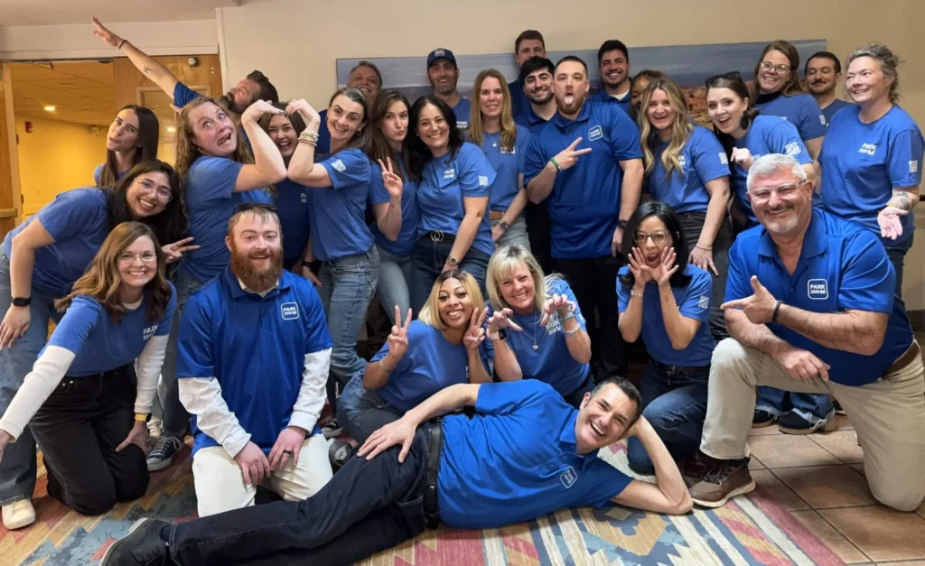 The ParkM team together in blue ParkM shirts, posing for a group photo